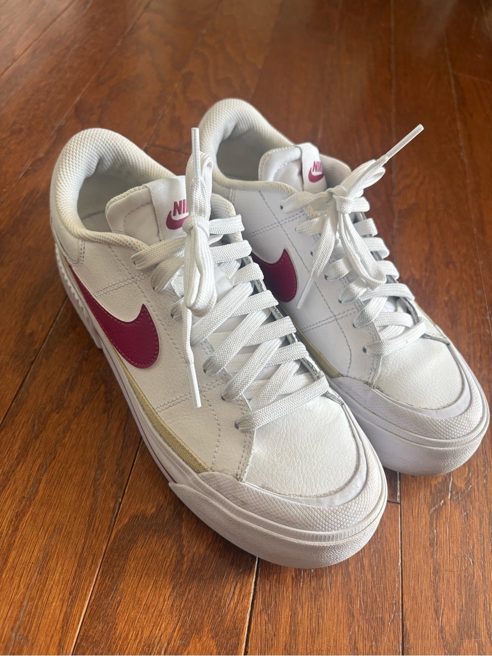 Nike Women’s White Sneakers with Pink Swoosh and Gold Accent